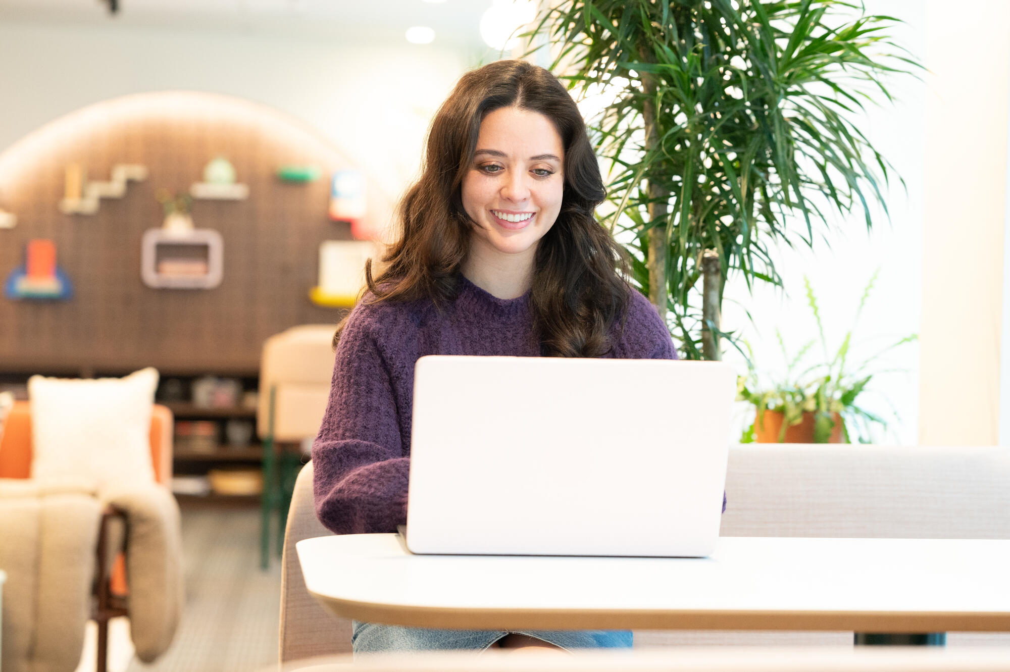 a person sitting at a table with a laptop