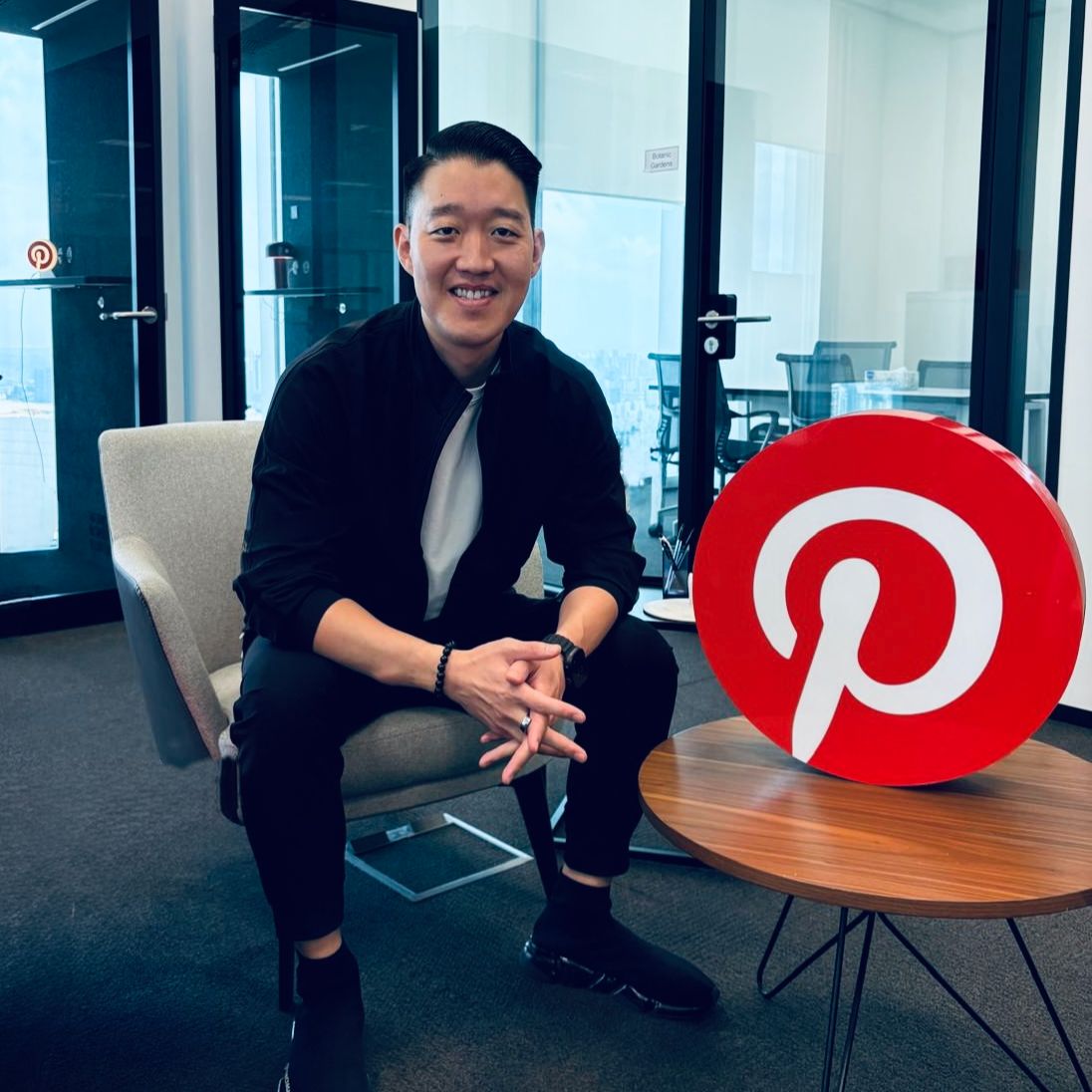 a person sitting in a chair with a pinterest logo on it