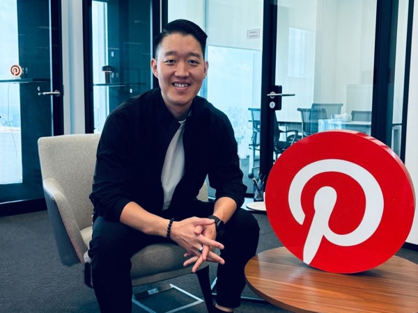 a person sitting in a chair with a pinterest logo on it