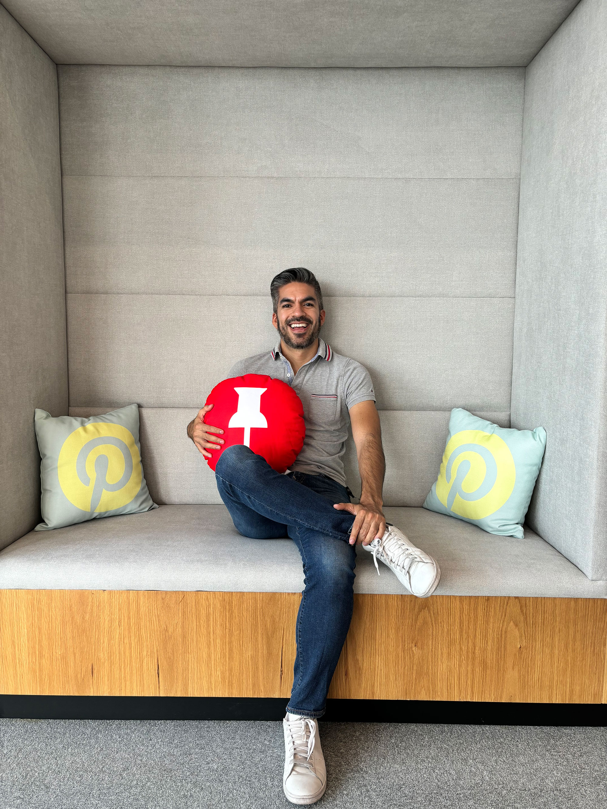 a man sitting on a couch holding a red ball