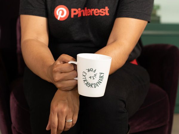 a person holding a white mug