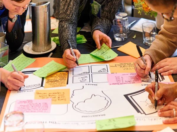 a group of people sitting around a table with sticky notes