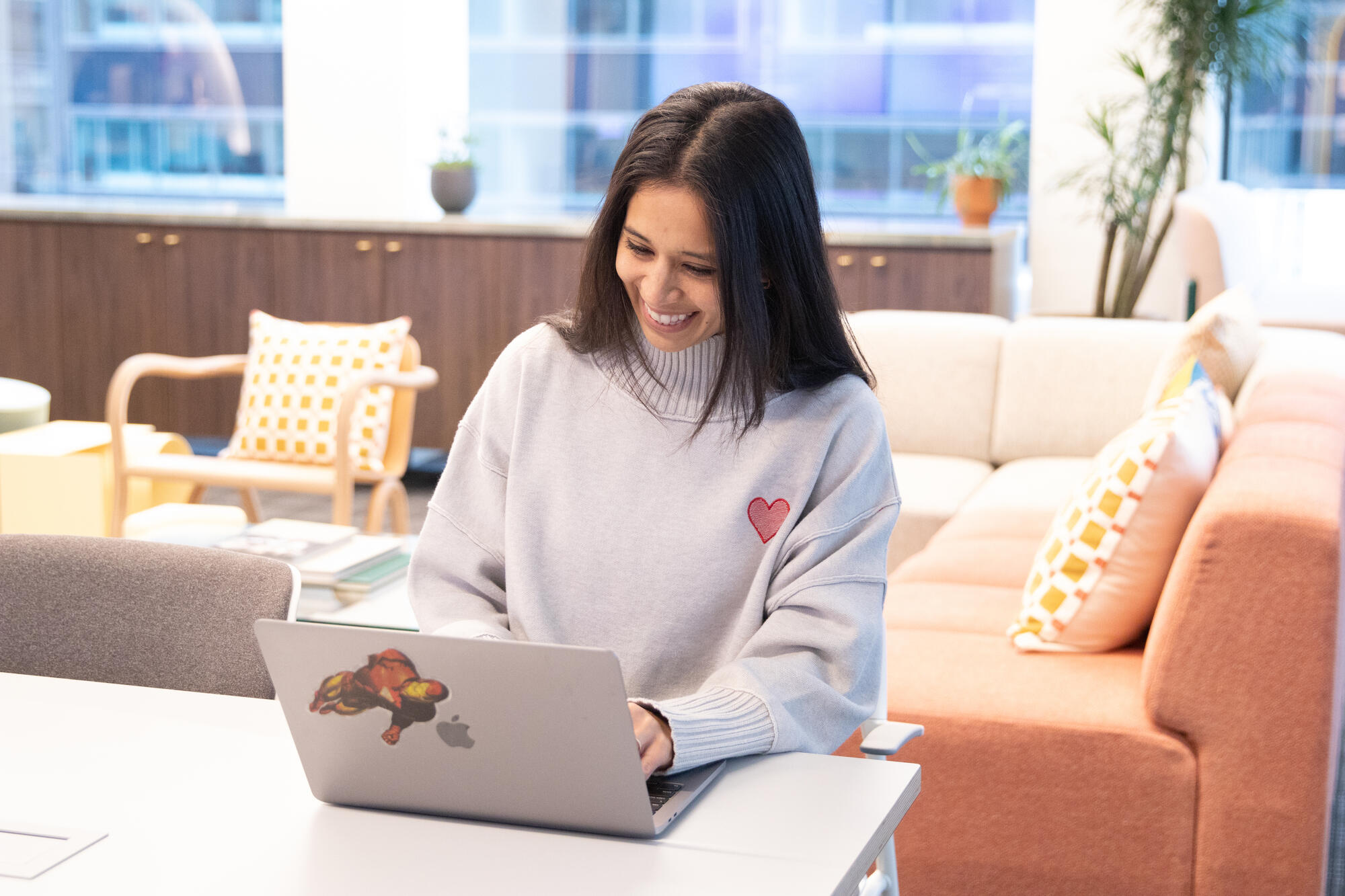 a person sitting at a table using a laptop