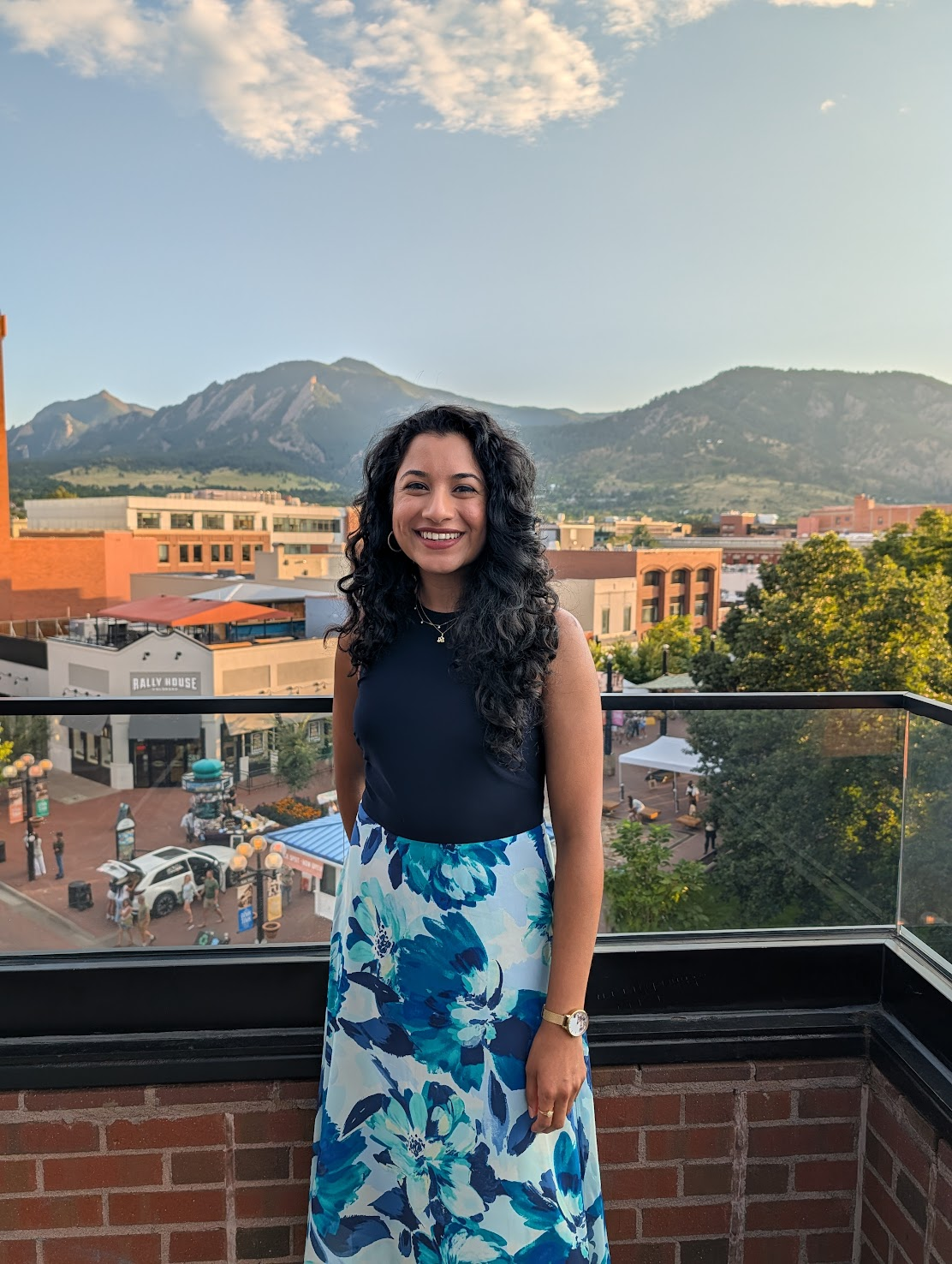 a person standing on a balcony with a view of a town and mountains in the background