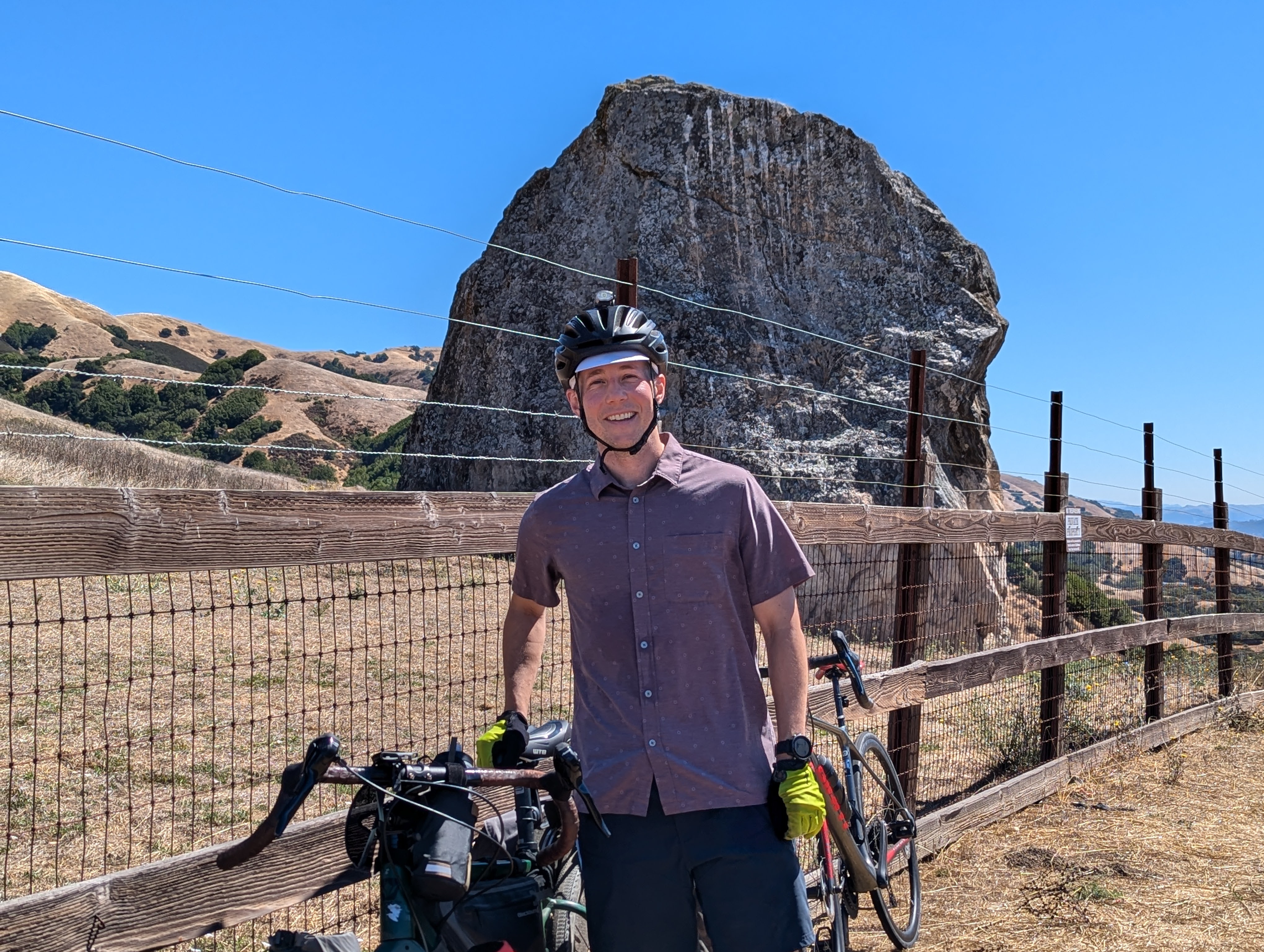 a person wearing a helmet and holding a bicycle