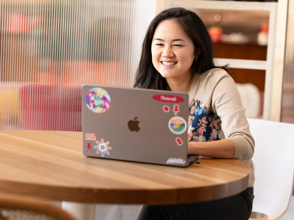 a woman sitting at a table with a laptop