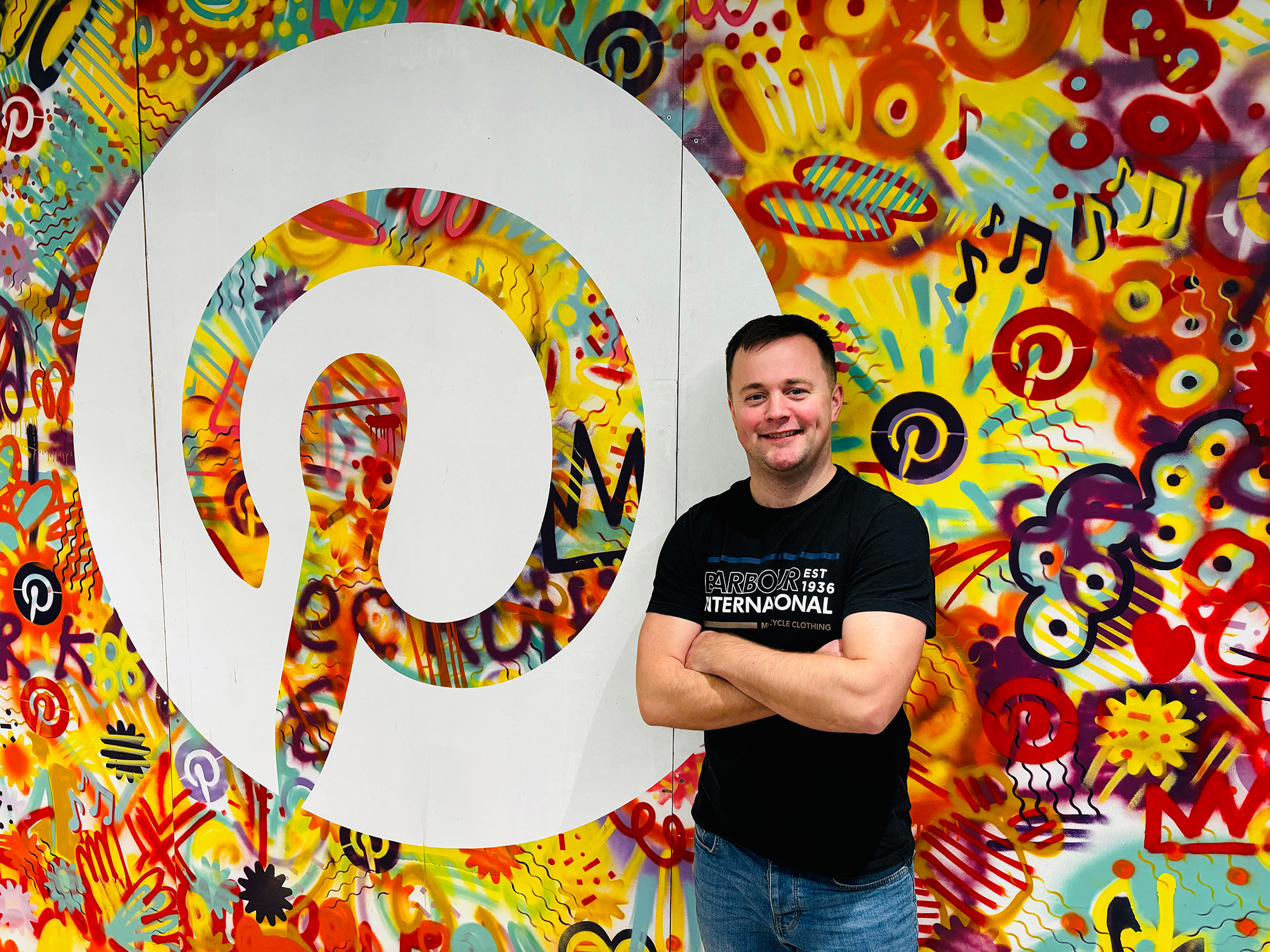 a man standing in front of a mural
