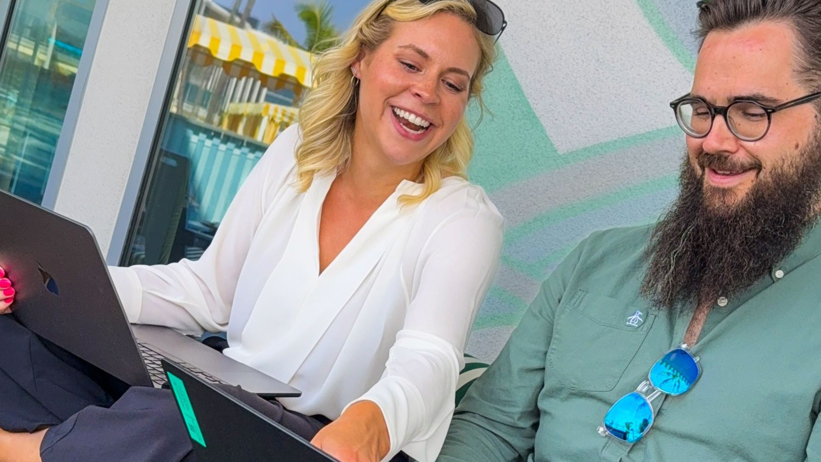 a person smiling at a laptop