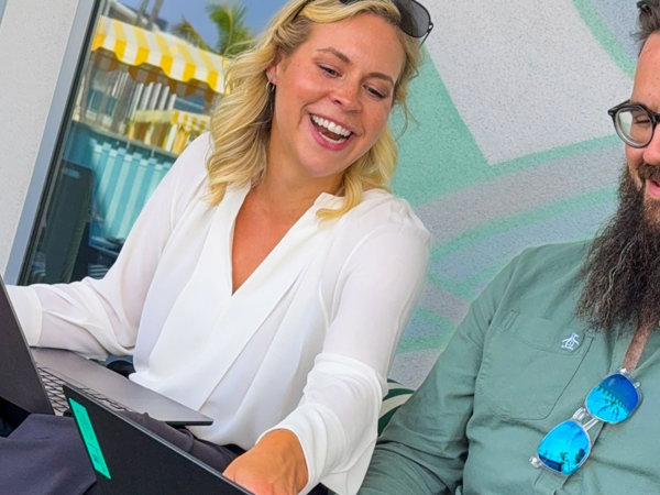 a person smiling at a laptop