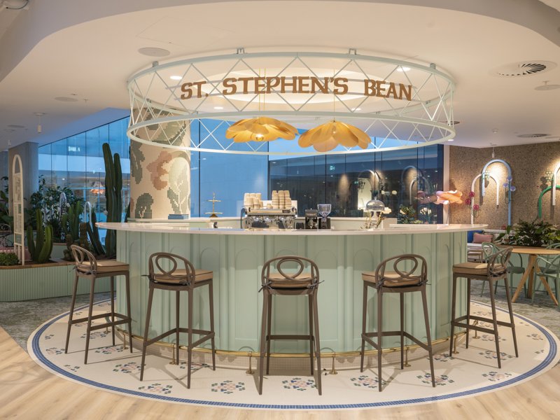 a bar with chairs and a sign above it