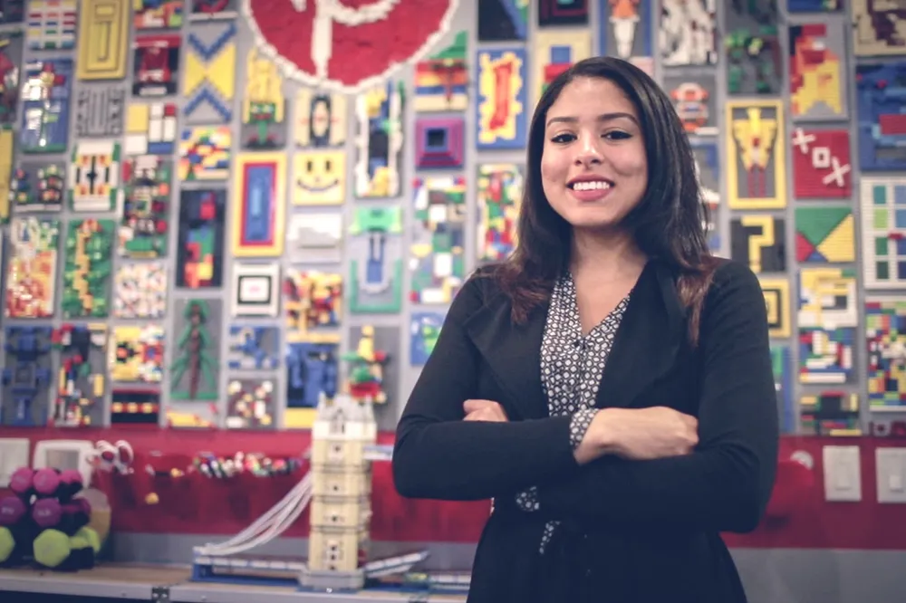 a person standing in front of a wall of lego pieces