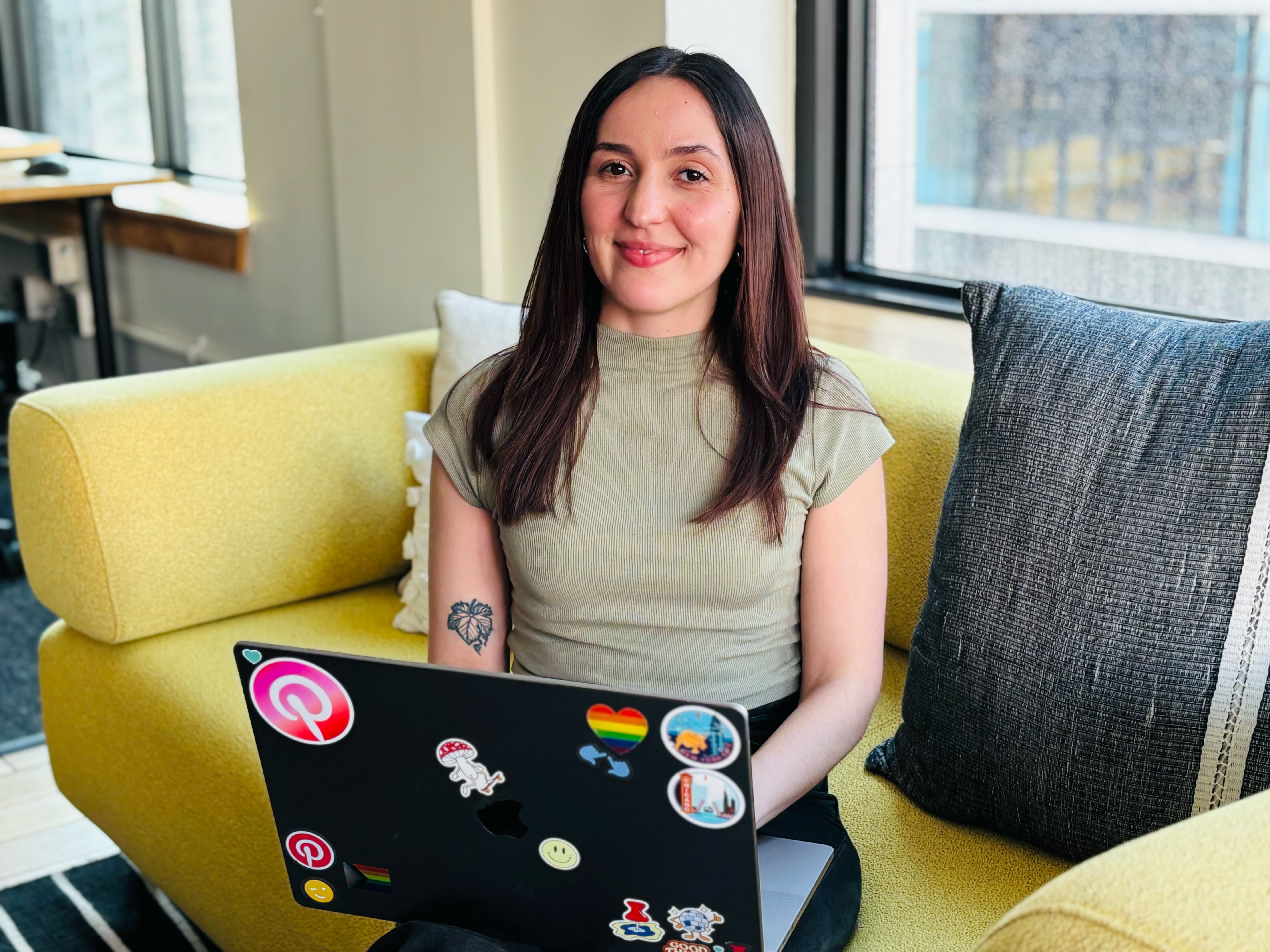 a person sitting on a yellow couch with a laptop