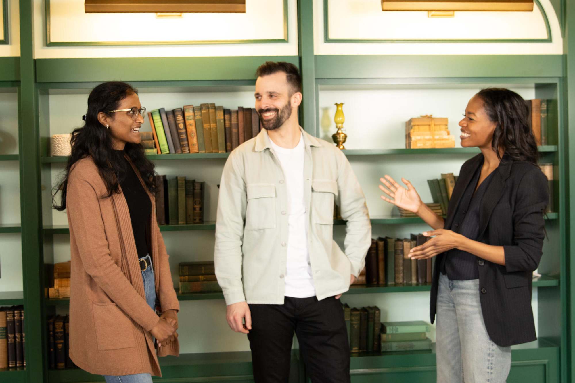 a group of people standing in front of a book shelf