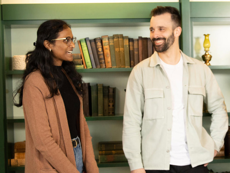 a group of people standing in front of a book shelf
