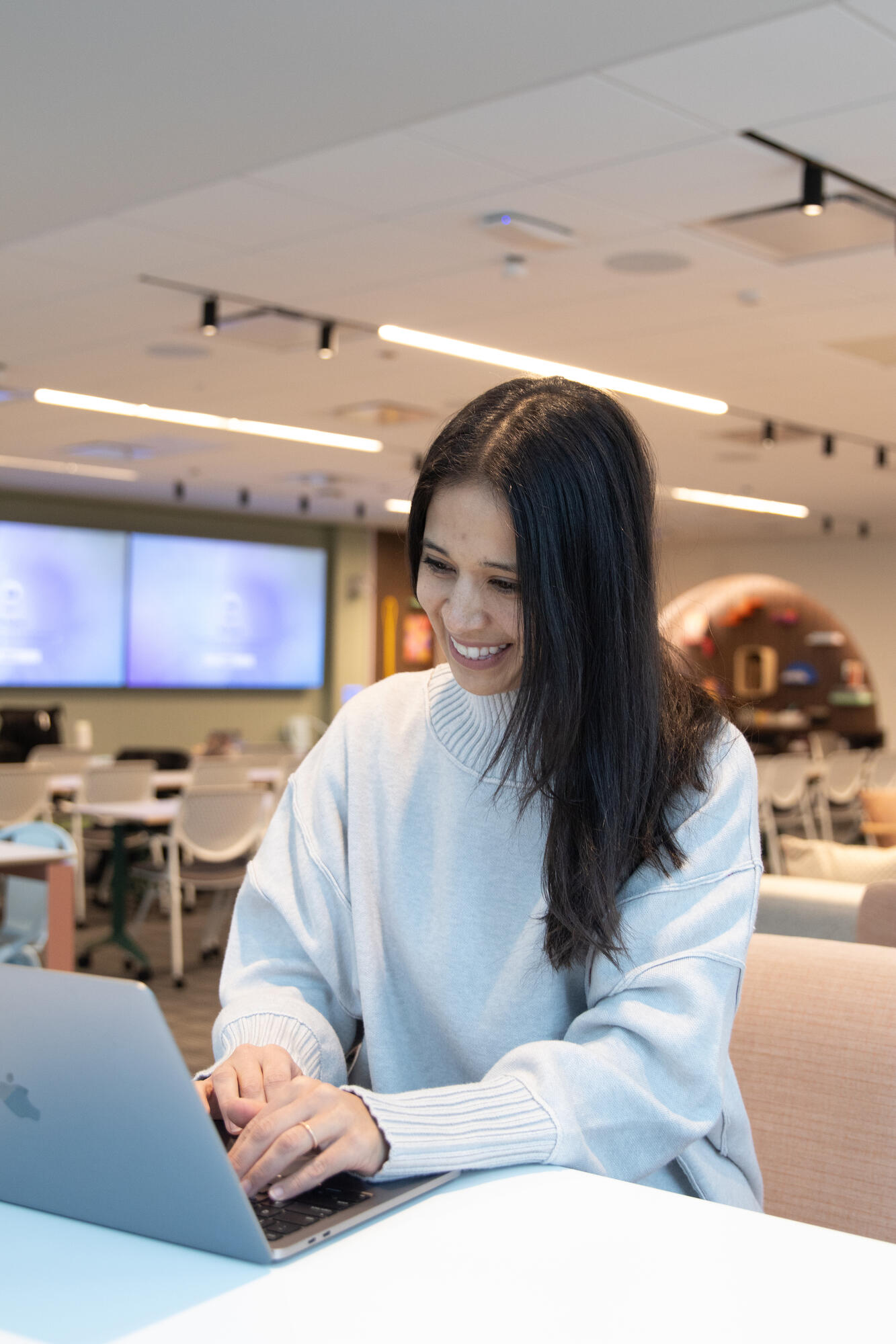 a person smiling at a laptop