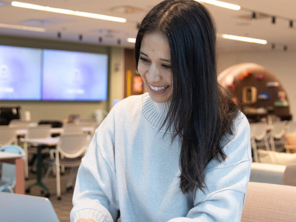a person smiling at a laptop