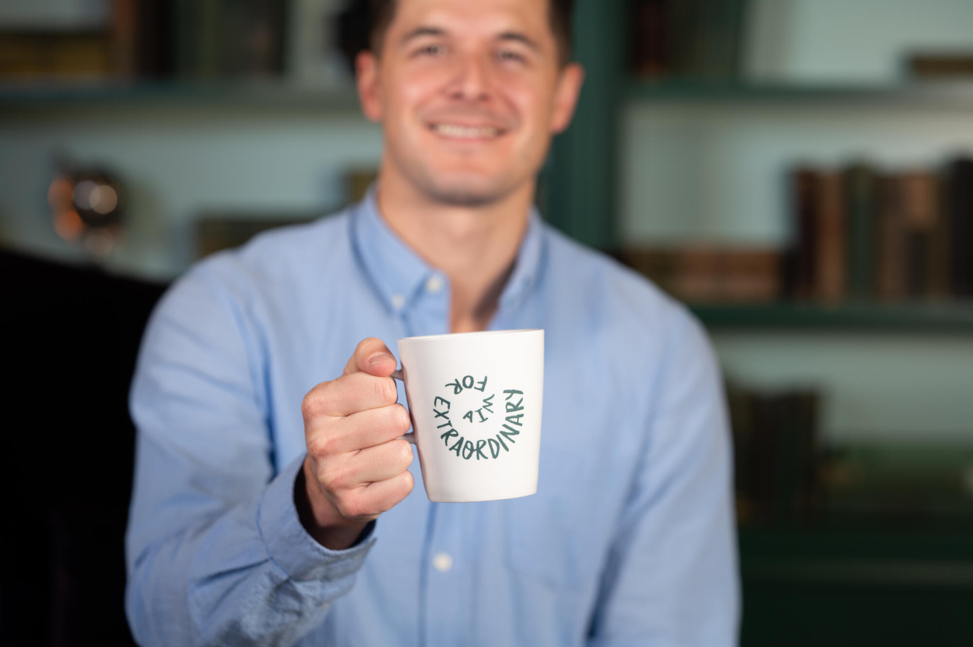 a man holding a white mug with writing on it