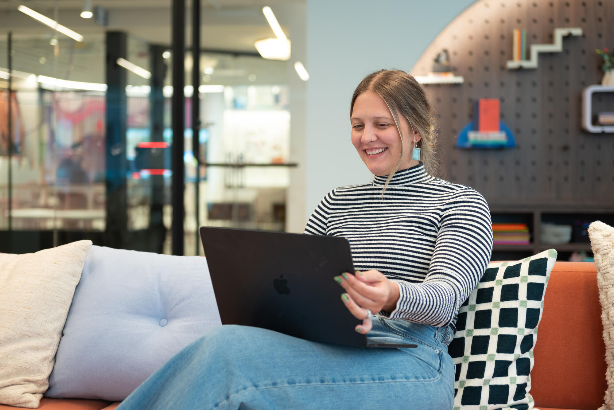 a person sitting on a couch using a laptop