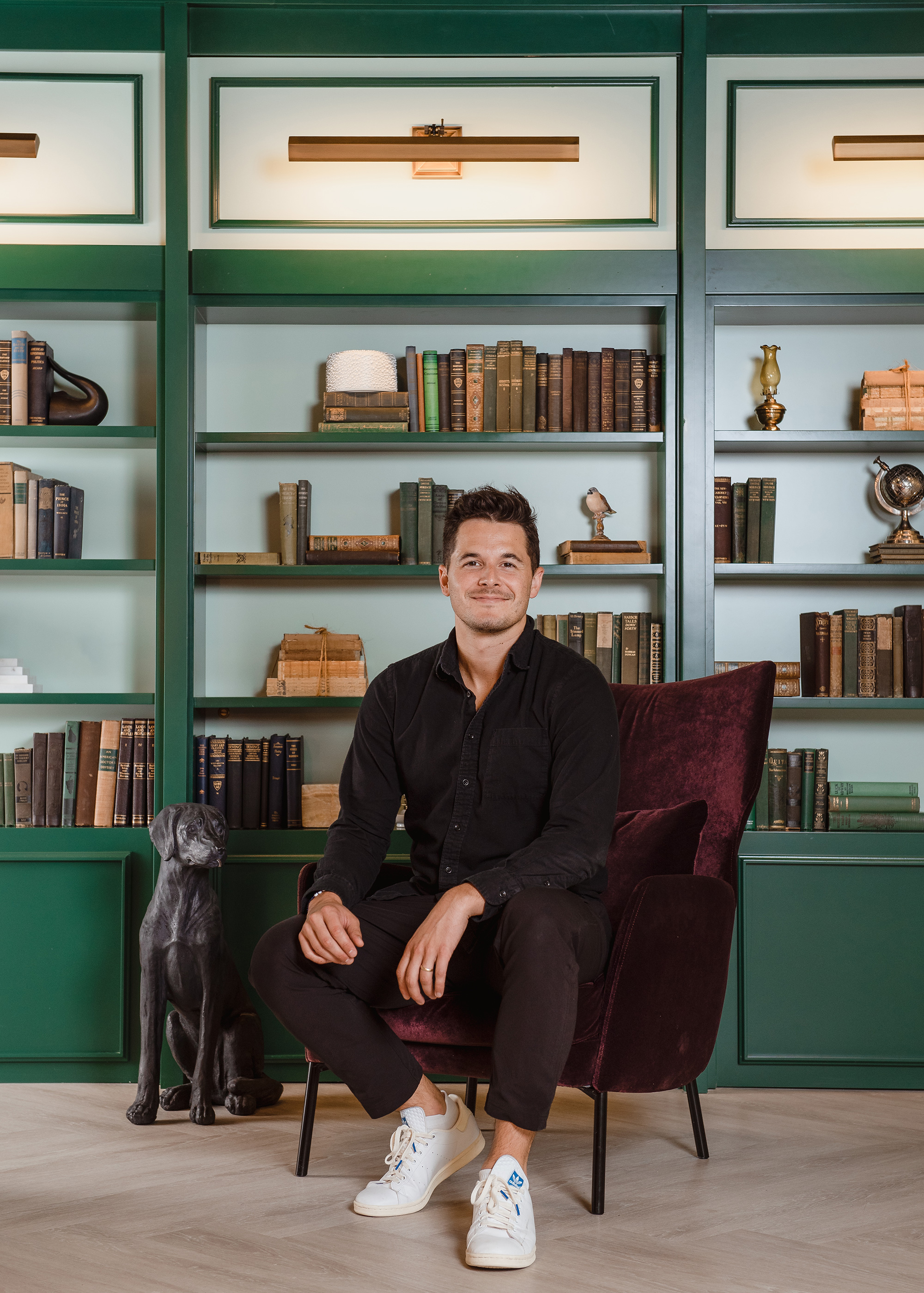 a man sitting in a chair in front of a bookcase