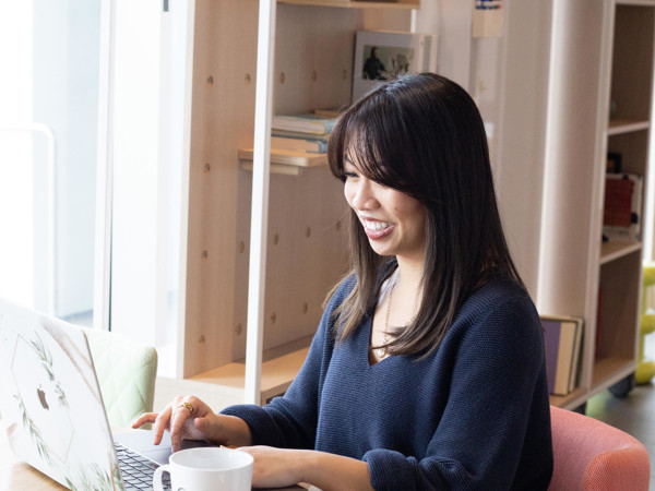 a woman sitting at a table using a laptop