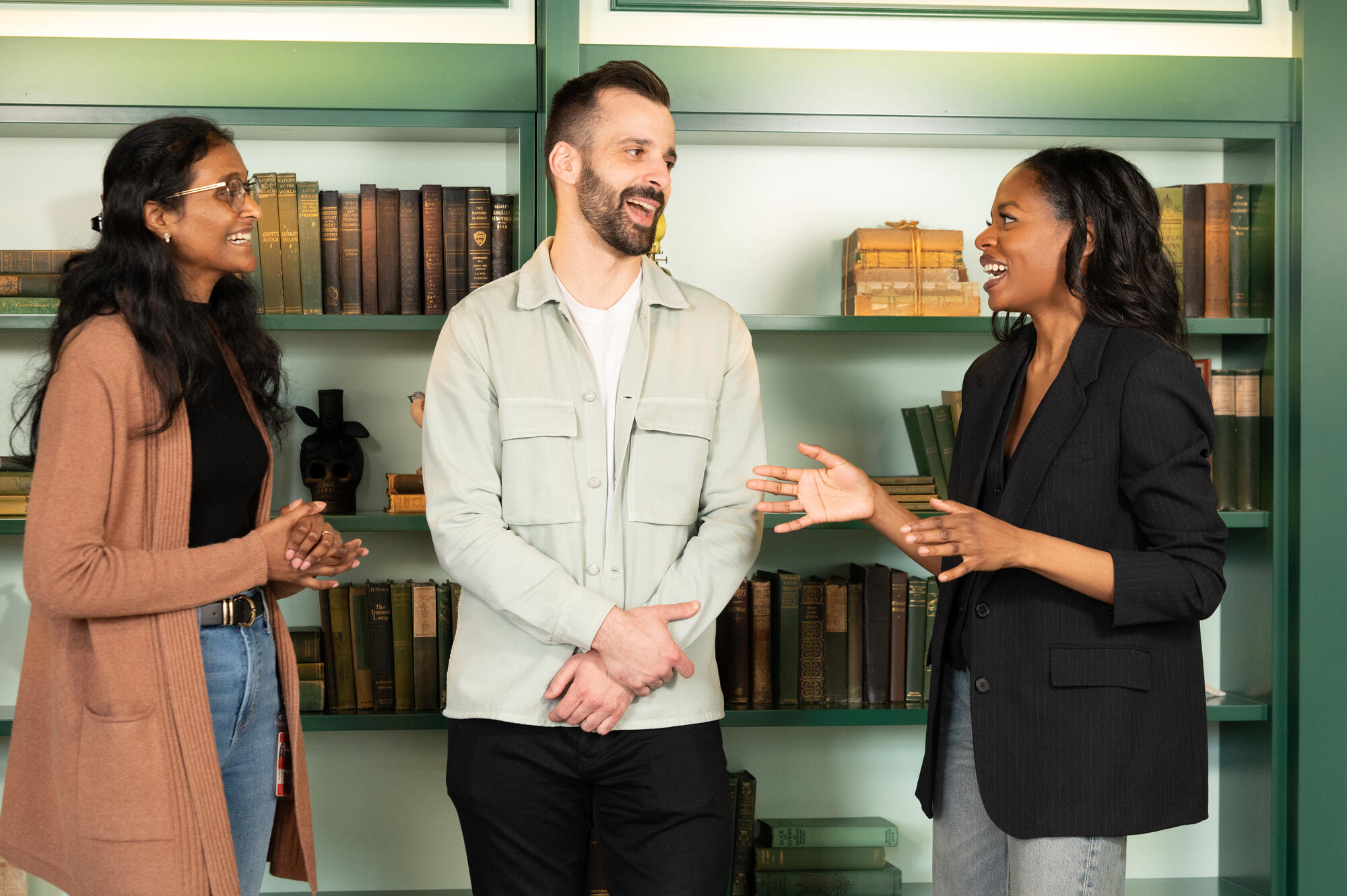 a group of people standing in front of a bookshelf
