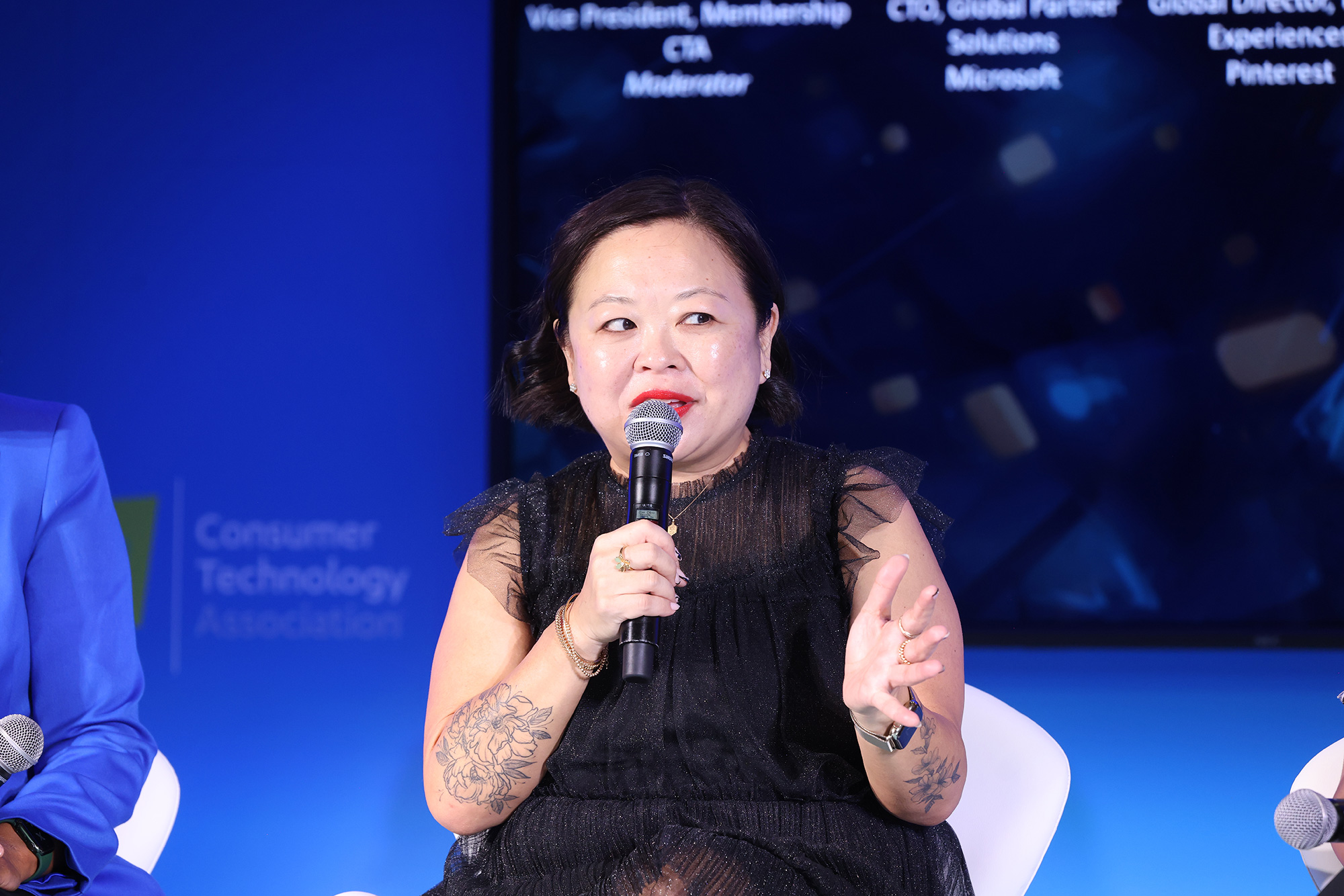 a woman in a black dress holding a microphone