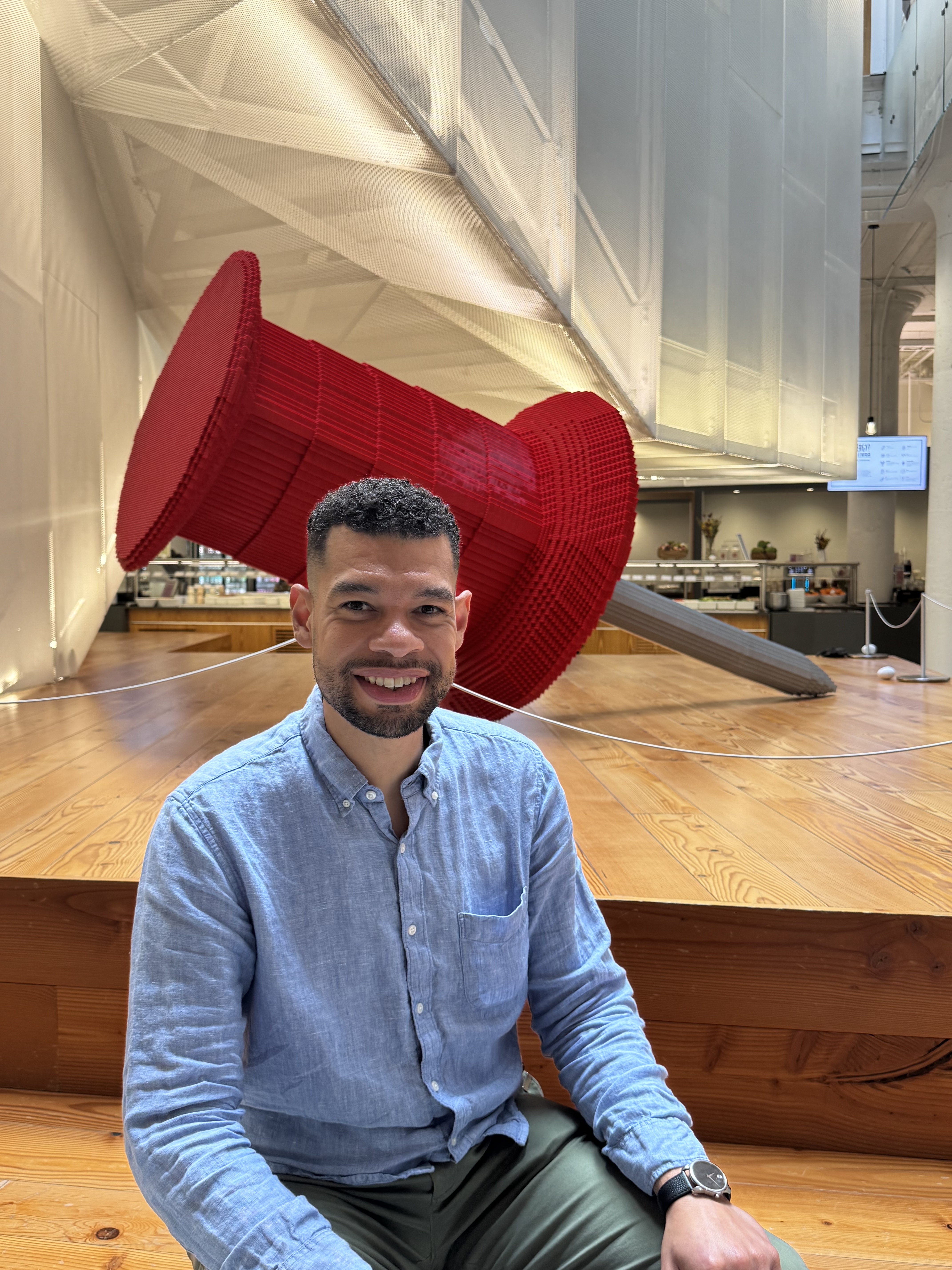 a person sitting in front of a large red object