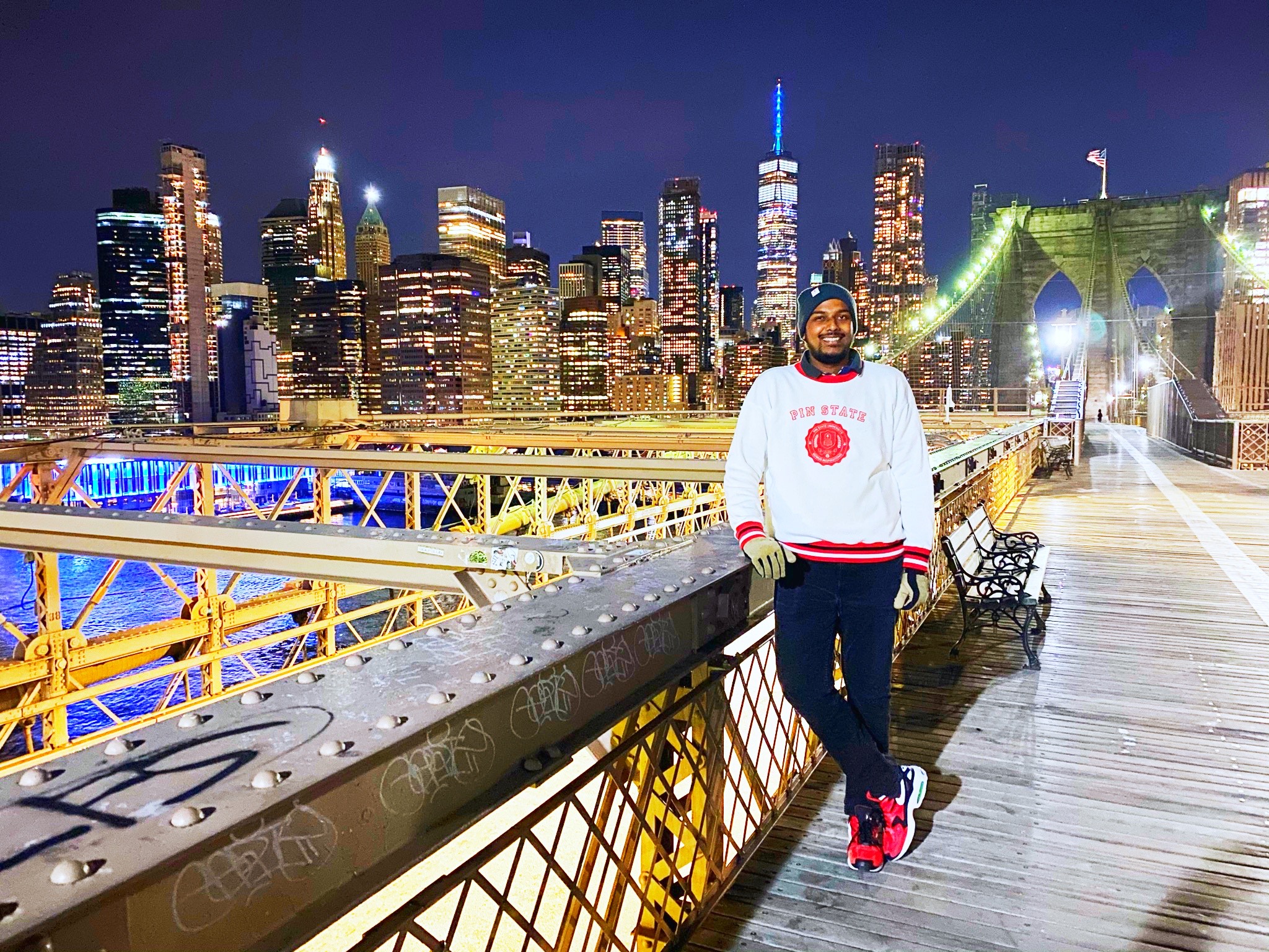 a man standing on a bridge with a city in the background