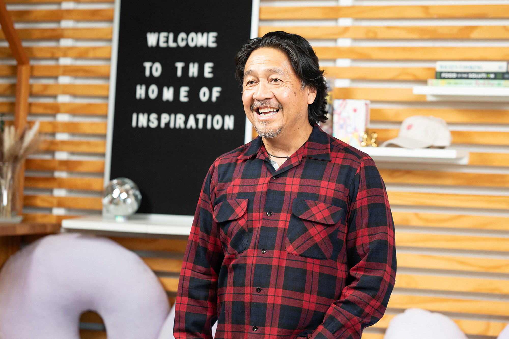 a man smiling in front of a sign