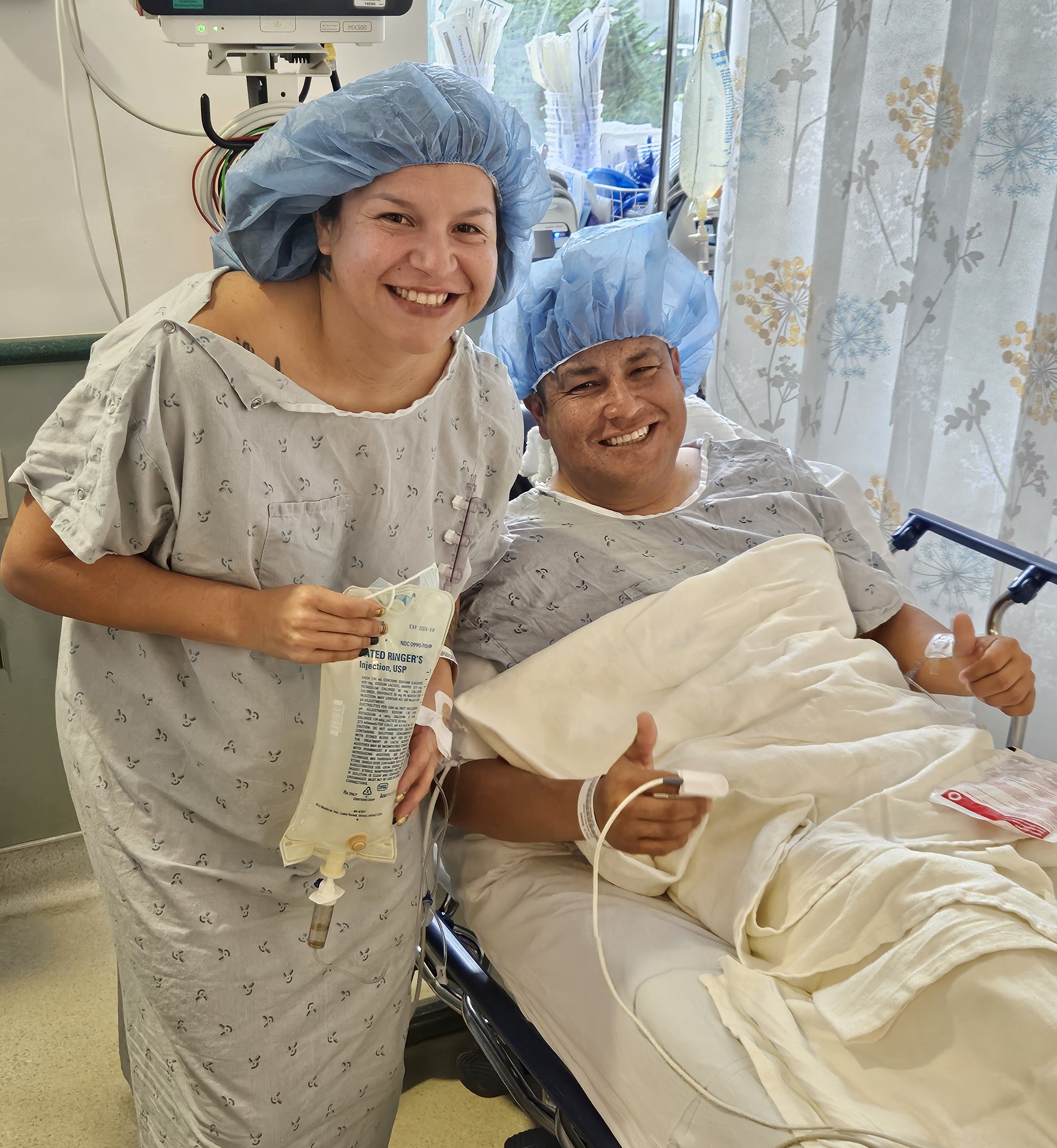 a person and person in hospital gowns and hair caps smiling