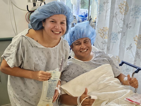 a person and person in hospital gowns and hair caps smiling