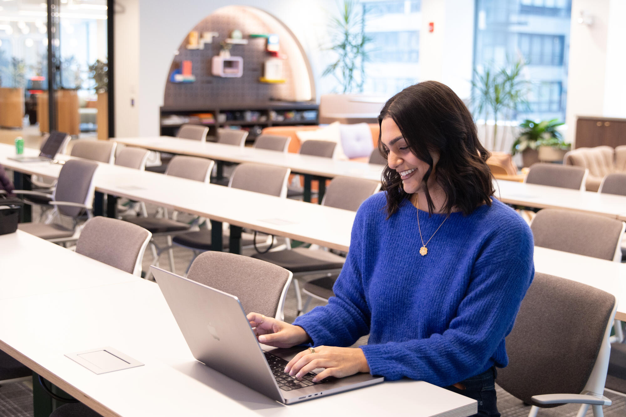 a person sitting at a table using a laptop