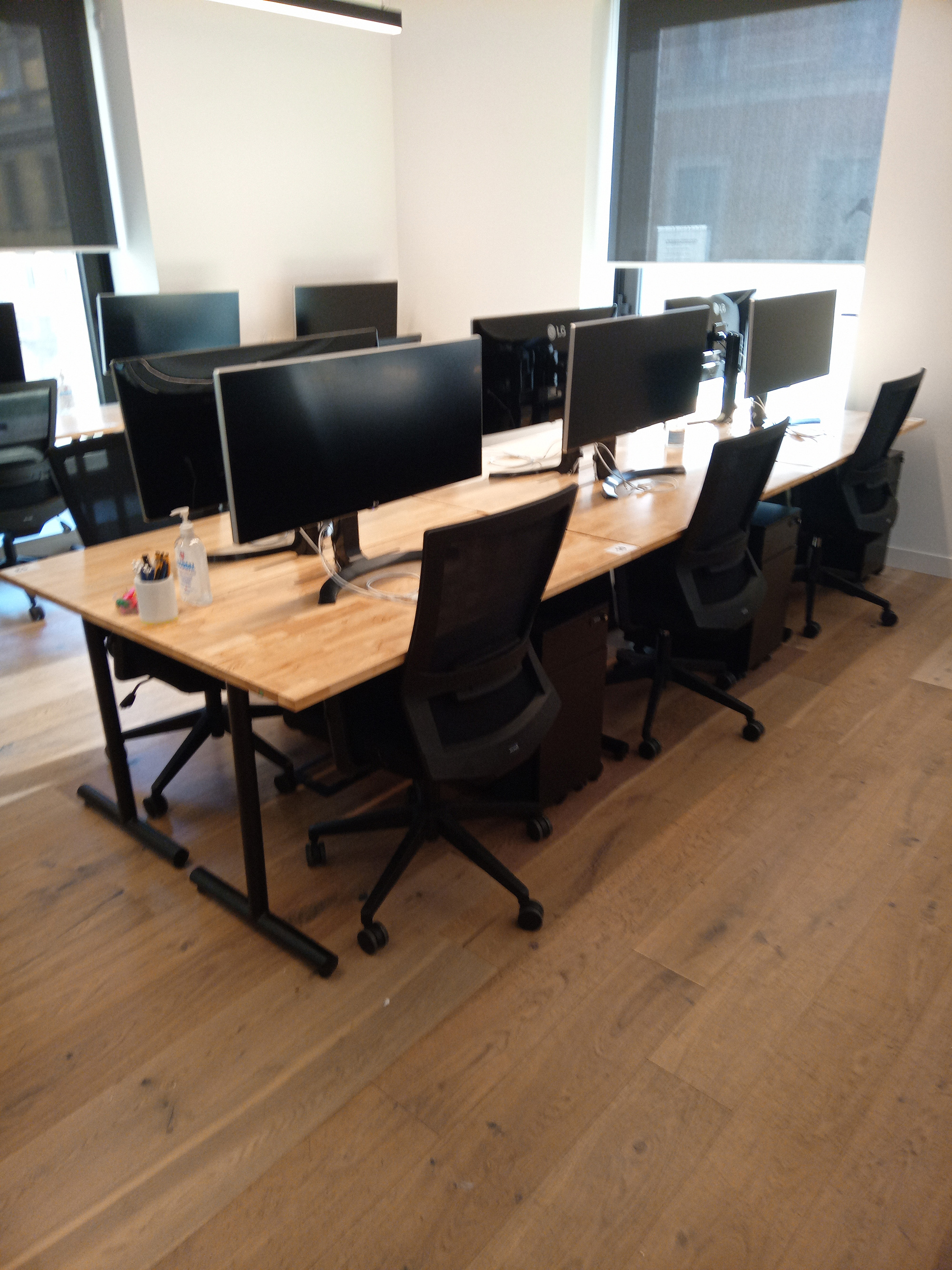 a desk with computers and chairs