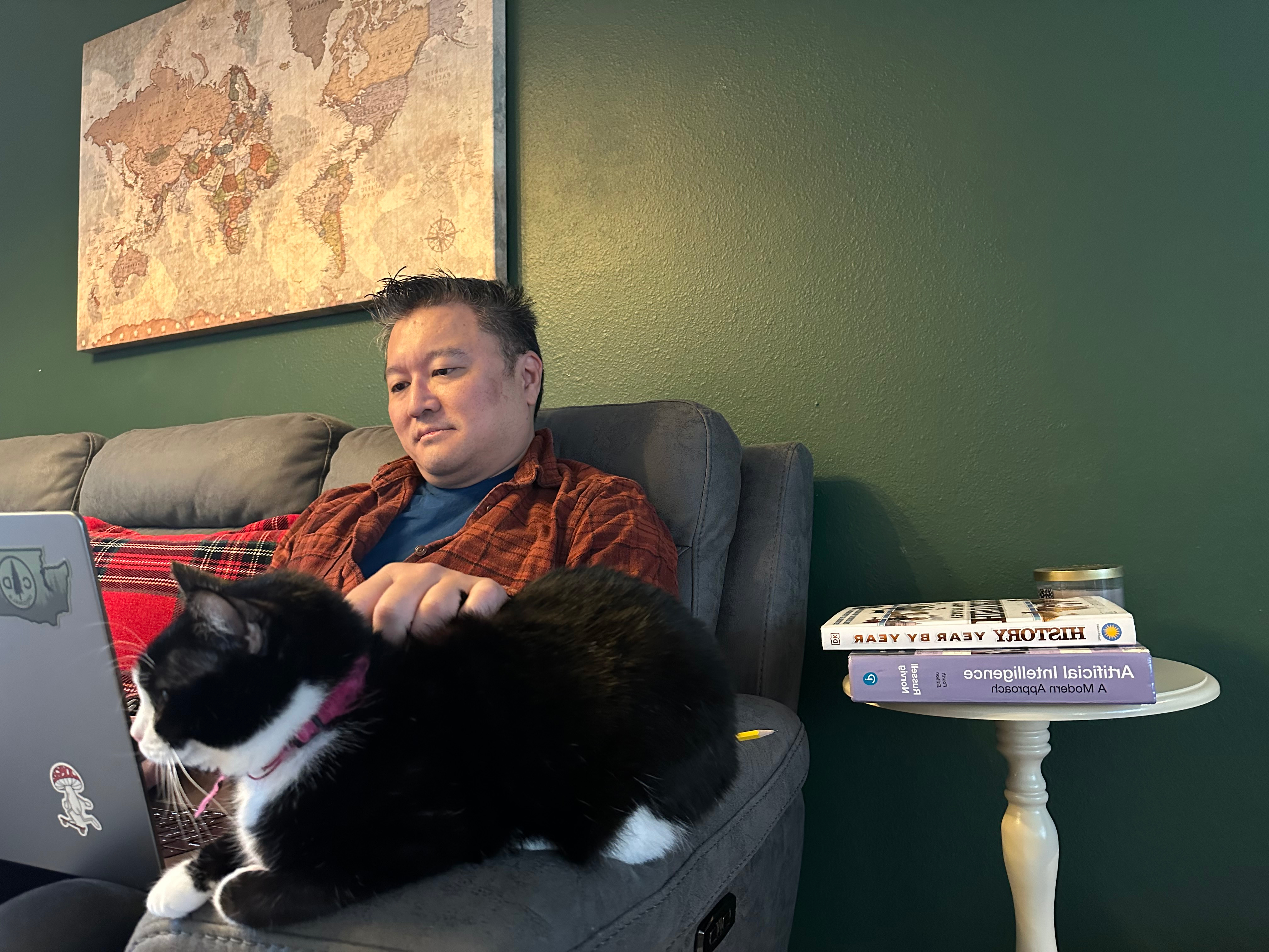 a man sitting on a chair with a cat