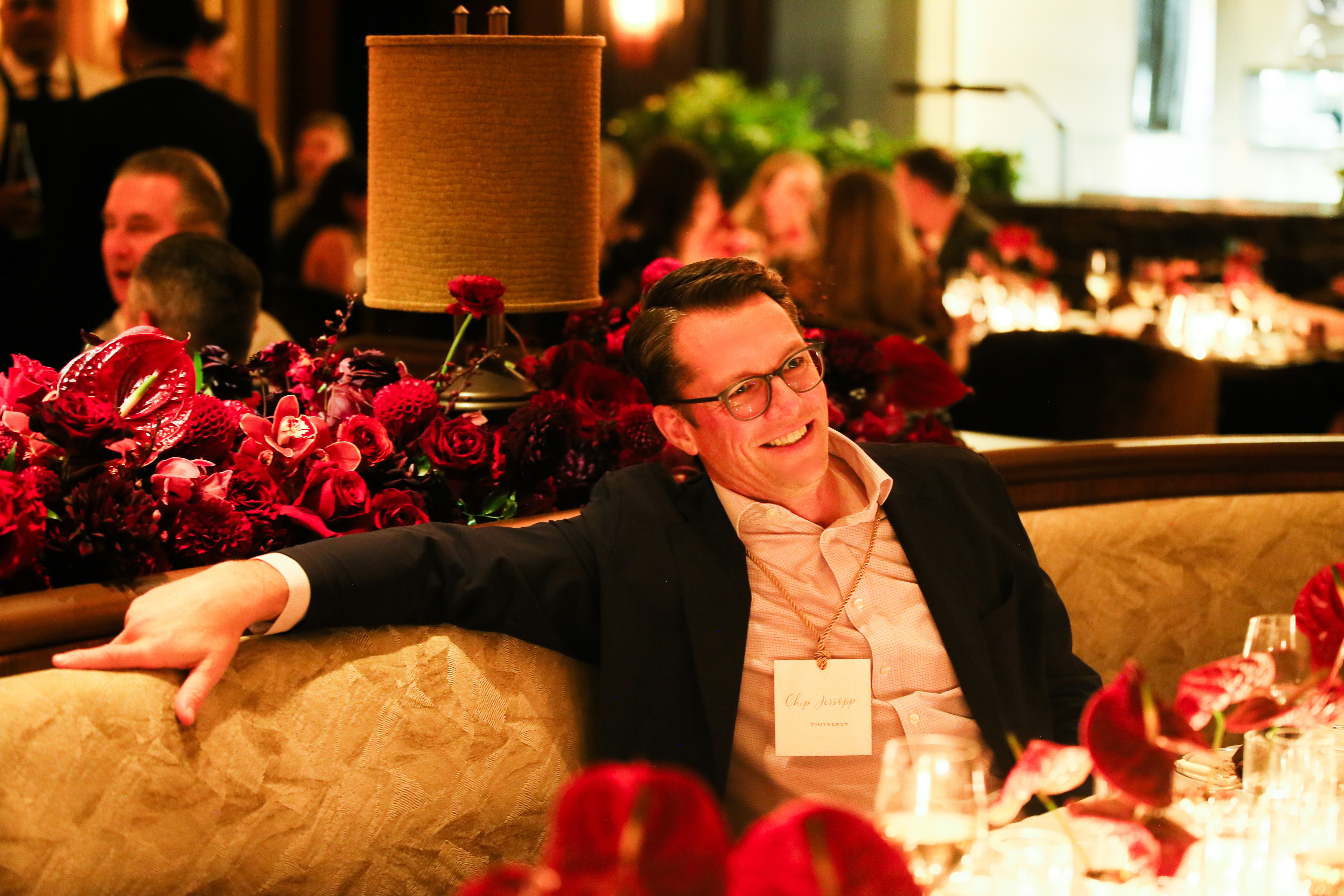 a person sitting on a couch with a bunch of flowers in the background