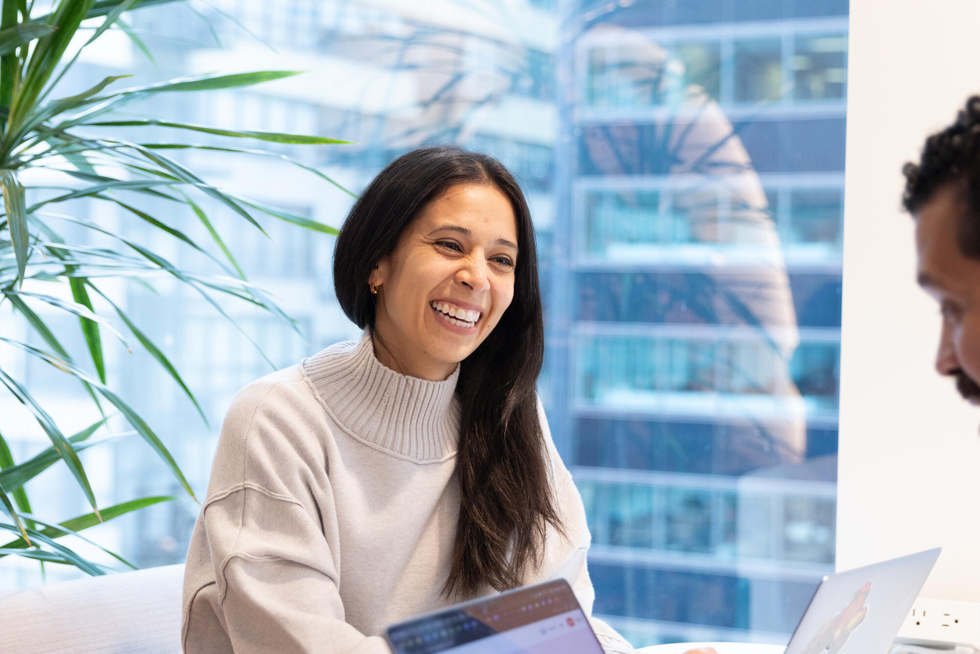 a person smiling at a laptop