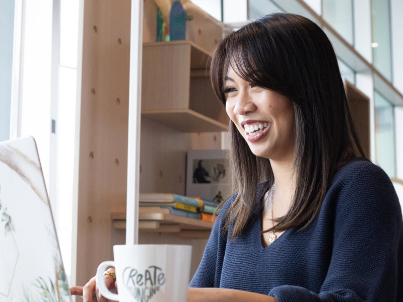 a person smiling at a coffee cup
