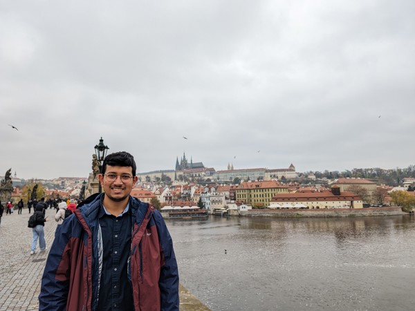 a man standing on a bridge with a city in the background