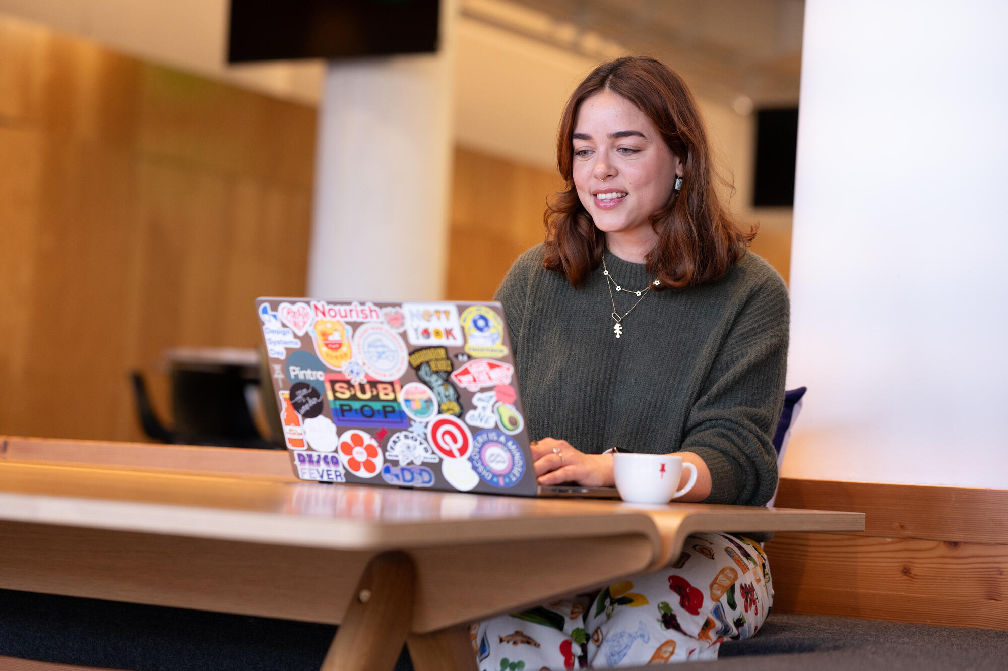 a person sitting at a table with a laptop