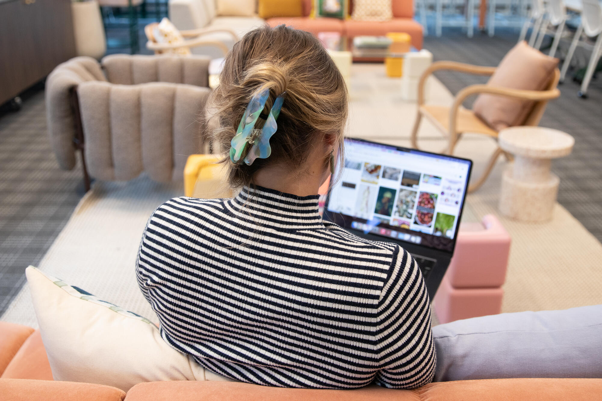 a person sitting on a couch using a laptop