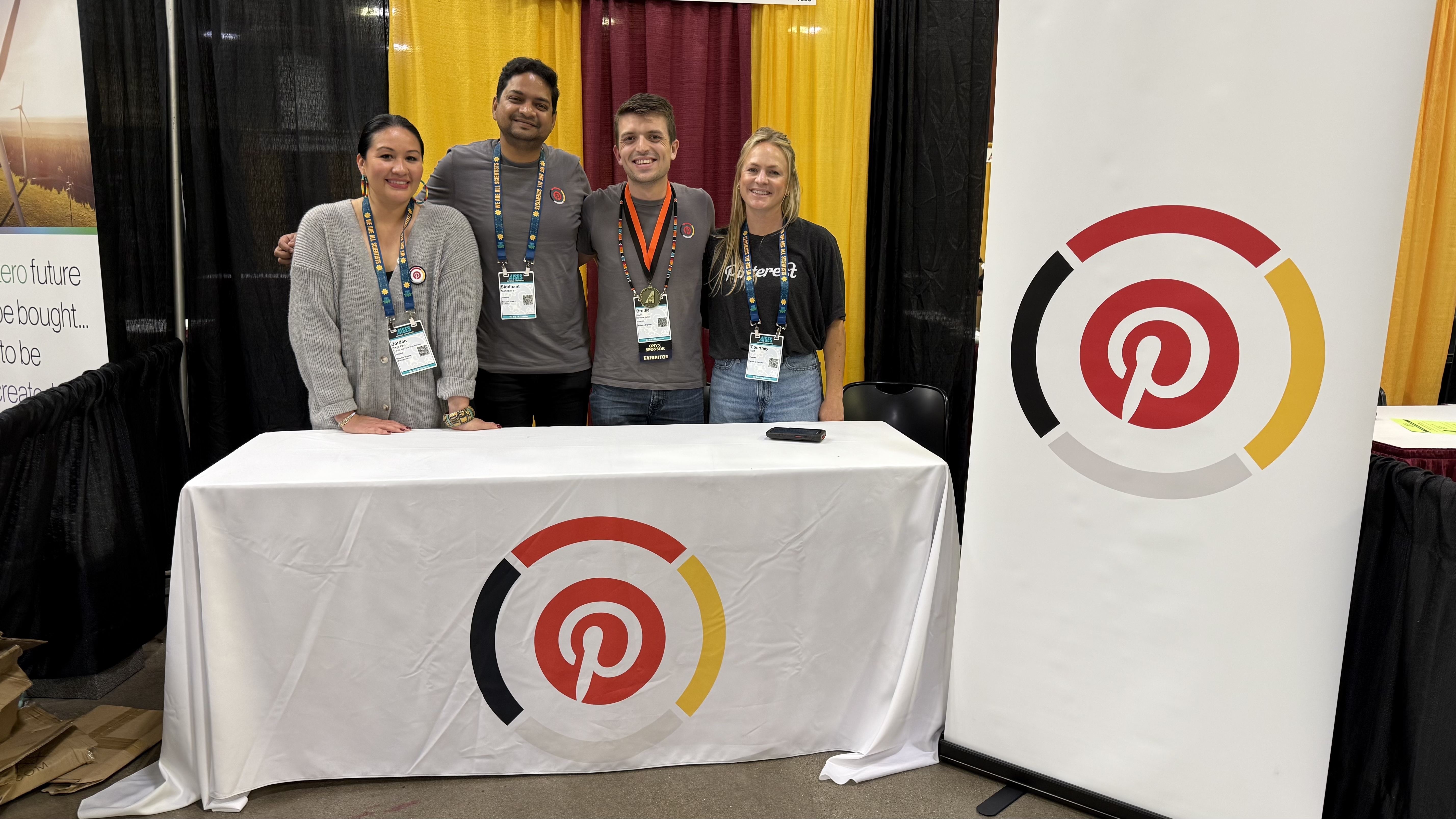 a group of people standing in front of a table with a white tablecloth