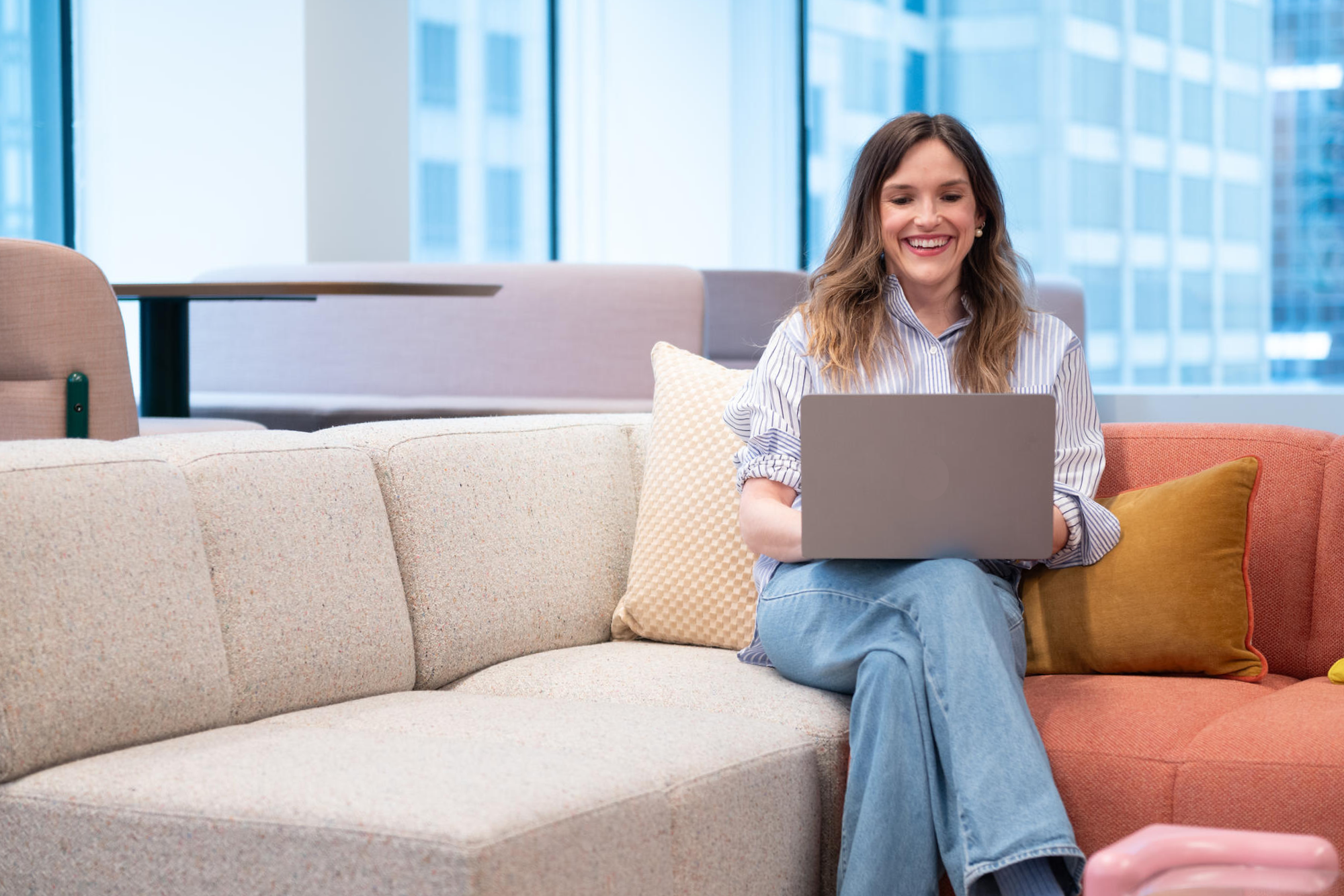 a person sitting on a couch using a laptop
