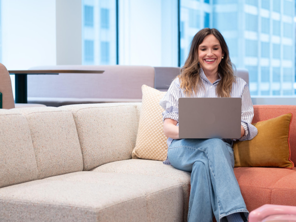 a person sitting on a couch using a laptop