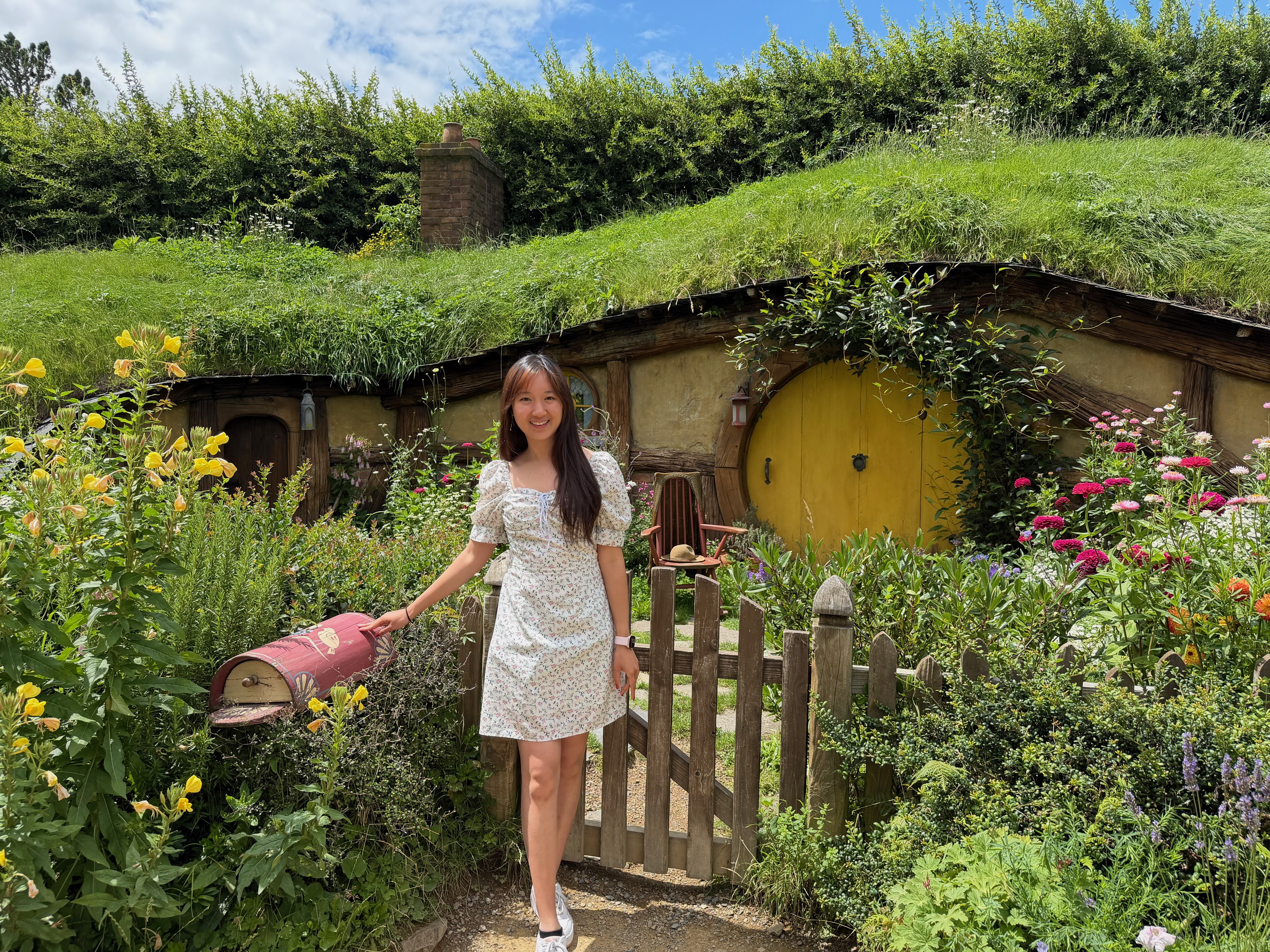 a person in a dress holding a mailbox in front of a house
