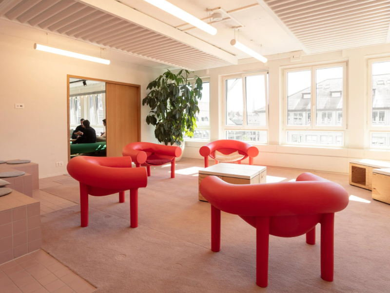 a room with red chairs and a table